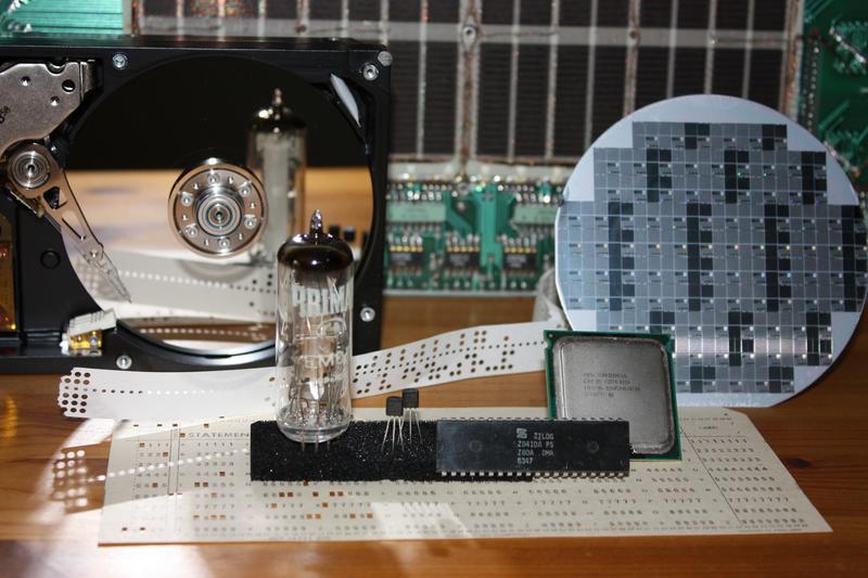 Images of some early computer parts. At the back: core memory (tiny tiny doughnuts of metal woven onto wires). At the front: A punched card